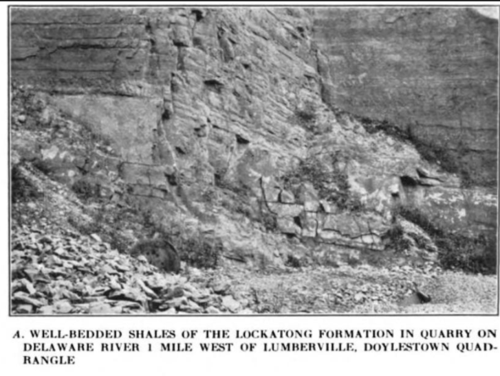 An old photograph of a rock face on a cliff. The rocks are blocky and fractured and there are rubble piles at the base of the cliff