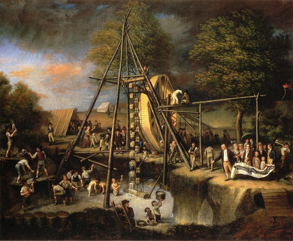 A large excavation of fossils with a giant wheel and dozens of people digging into the ground.